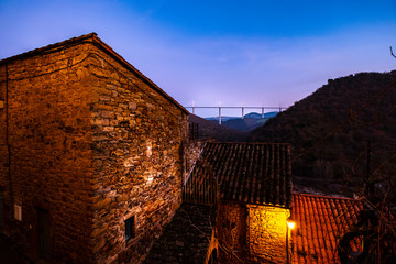 View of the Millau viaduct on the A-75 motorway during sunset from the village of Peyre from the...