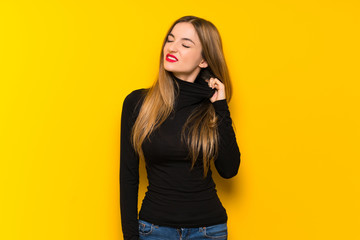 Young pretty woman over yellow background with tired and sick expression