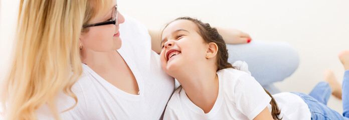 mother and baby are looking to play and read tablet computer on the couch at home