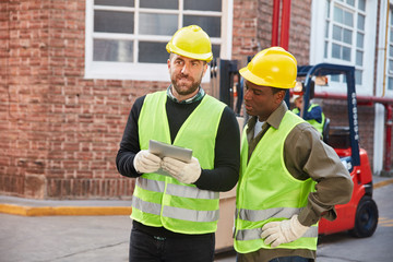 Zwei Lagerarbeiter mit Tablet Computer