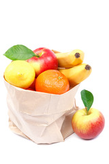 Fresh bananas, lemon, tangerines, apples in a paper bag