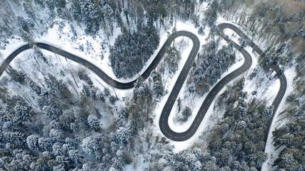 windy road aerial with snow covered trees