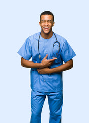 Surgeon doctor man smiling a lot while putting hands on chest on isolated background