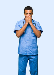 Surgeon doctor man smiling a lot while covering mouth on isolated background