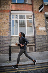 Fototapeta na wymiar Woman jogging through the city