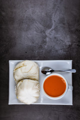 Hot Thai tea in the white cup and steamed buns recipes with salted egg for breakfast