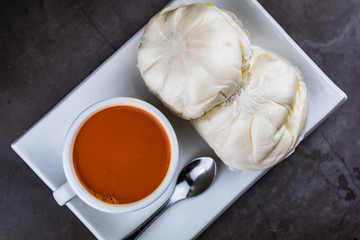 Hot Thai tea in the white cup and steamed buns recipes with salted egg for breakfast