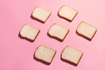Sliced bread to toast isolated on pink background. Close up. Top view