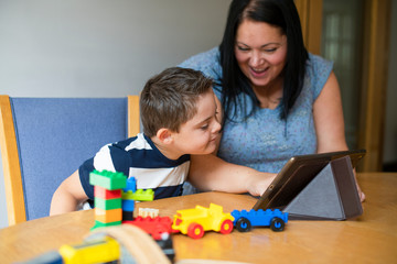 Mother teaching son from a tablet