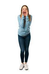 Fototapeta premium Full body of Blonde woman with blue shirt shouting and announcing something on white background