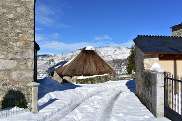 Ancient snowy palloza house made with stone and straw. Piornedo mountain village, Ancares Region, Lugo Province, Spain.