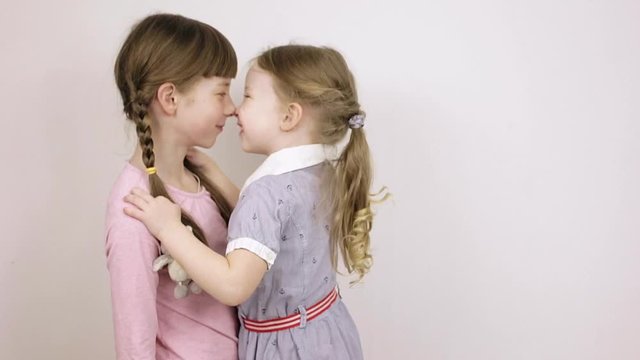 two sisters play and have fun, children's emotional portraits on white background