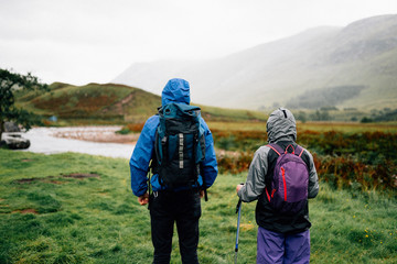Couple trekking through the rain in the Highlands