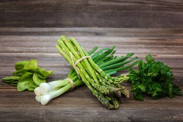 Asparagus, onion and parsley green fresh on a wooden