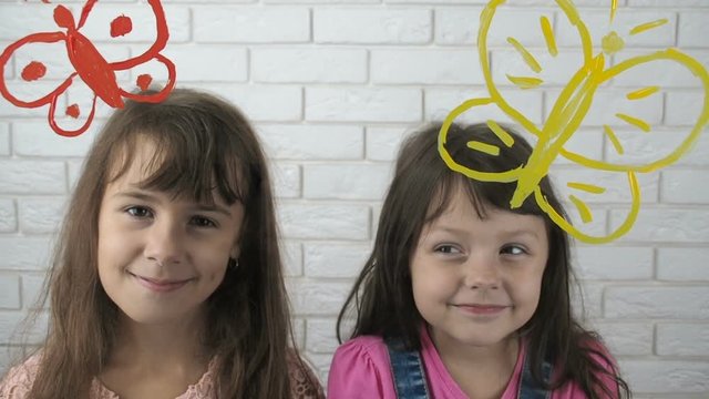 Children with butterflies. Cute little girls with painted butterflies.