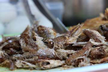 Pile of crispy fish on the tray for sale.