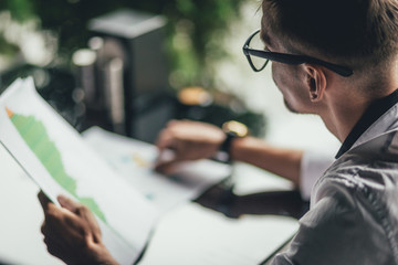 Businessman working, businessman in cafe, businessman looking at documents. Rear view. Selective focus