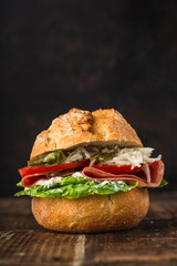 bread rolls topped with salami, salad, tomatoes