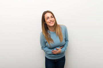 Blonde woman on isolated white background keeping the arms crossed while smiling