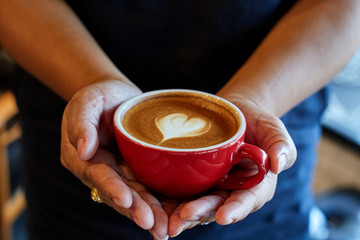 cup of latte coffee in woman hand