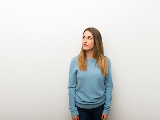 Blonde woman on isolated white background looking up with serious face