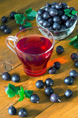 A glass with gooseberry juice and berries.