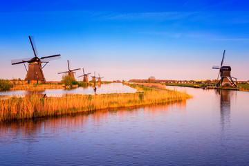 Amazing nature, scenic sunset landscape, windmills, blue sky and water. Traditional dutch countryside, famous village of mills Kinderdijk, popular tourist attraction in Netherlands (Holland)