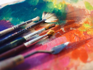 Obraz premium Drawing tools on the palette are illuminated by the sun, which is scattered strokes