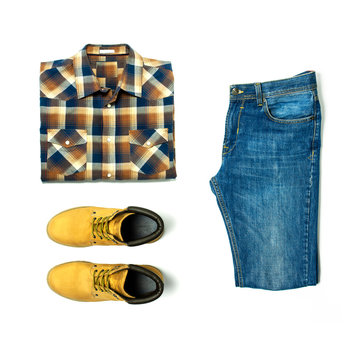 Flat lay set Men's casual clothing, blue jeans, checkered shirt, yellow nubuck shoes, strap isolated items on white background top view with space for text. Male fashion, clothes for rest, travel.