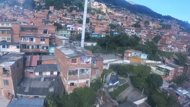 Slums of Medellin passing by seen from a cable car, colombian ghetto, top view above houses, South America