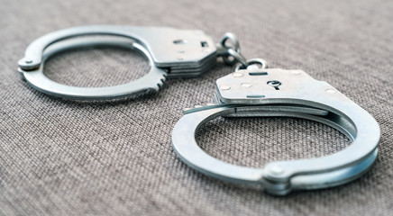 The cuffs on the table. Police unit. Close-up top view selective focus.