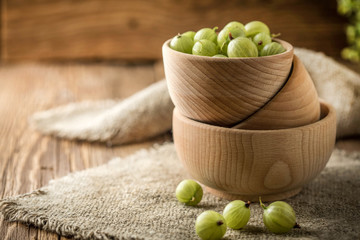 Fresh gooseberry in a wooden bowl.