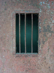 Metal door or wall fragment with barred window