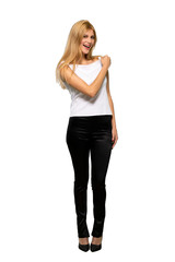 Fototapeta premium Young blonde woman smiling a lot over isolated white background