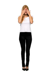 Young blonde woman covering eyes by hands. Do not want to see something over isolated white background