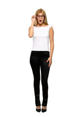 Fototapeta premium Young blonde woman with glasses and surprised over isolated white background