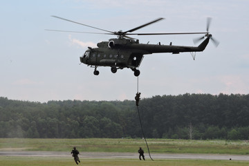 Deploying troops from a military helicopter using fast-roping technique - obrazy, fototapety, plakaty