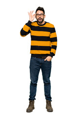 Full-length shot of Handsome man with striped sweater with glasses and surprised on isolated white background