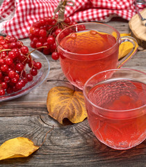 viburnum tea in a transparent cup on a gray wooden table