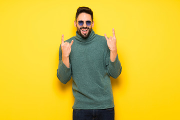 Handsome man with sunglasses making rock gesture