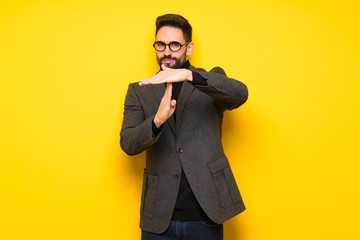 Handsome man with glasses making stop gesture with her hand to stop an act