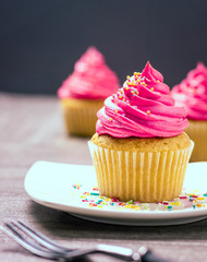 cupcakes with cheese cream and small decorative balls
