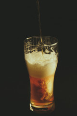 Glass of beer and croutons on a black background