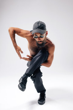 Hip hop dancer moving and jumping in photostudio