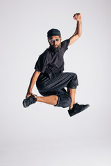 Hip hop dancer moving and jumping in photostudio