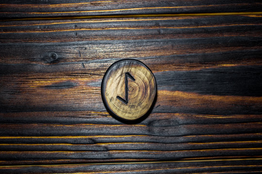Rune Eihwaz (Eihaz) carved from wood on a wooden background - Elder Futhark