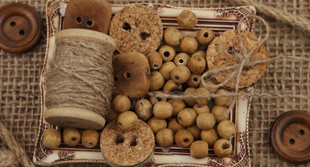Decorative composition with wooden buttons and accessories for sewing on burlap