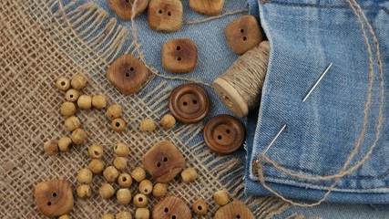 Decorative composition with wooden buttons and accessories for sewing on denim and burlap