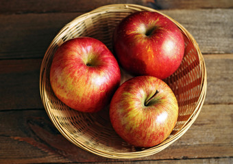 Three red apples in basket