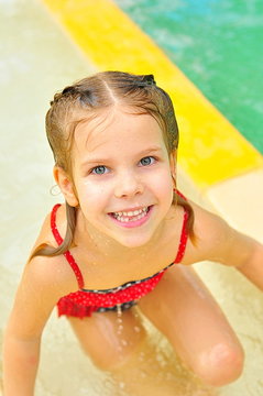 beautiful little girl with blue clases, blond hair and a sweet smile